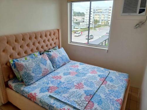a bed in a room with a window and a pillow at Riz's 2BR & 1T/Bath Condo 8 Spatial Maa 3f in Davao City