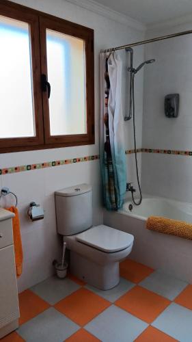 a bathroom with a toilet and a bath tub at Villa Puerto Adriano in El Toro