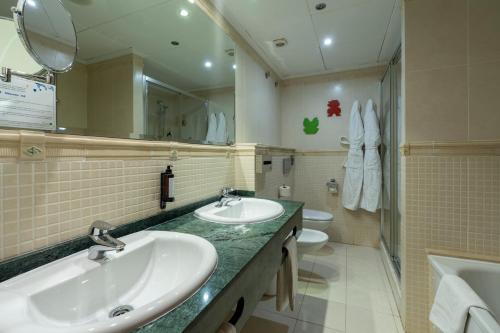 a bathroom with two sinks and a mirror and a toilet at Hotel Magic Games 4 in Oropesa del Mar