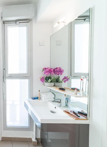 une salle de bain avec un lavabo et un miroir dans l'établissement Montempô Apparthôtel Marseille Centre Euromed, à Marseille