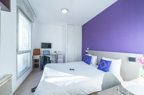 - une chambre avec un lit blanc et un mur violet dans l'établissement Montempô Apparthôtel Marseille Centre Euromed, à Marseille