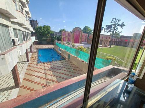a view of a swimming pool from a window at Hotel Maya international in Jaipur