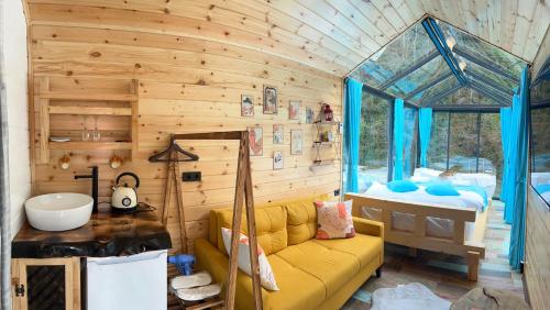 a living room with a yellow couch and a tub at River Land Rize in Ayder Yaylasi