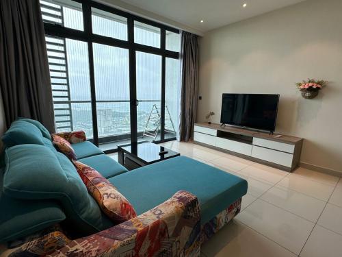 a living room with a couch and a flat screen tv at Cozy couple apartment suite in Masai
