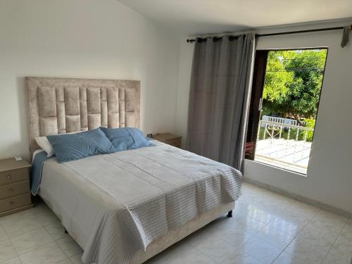 1 dormitorio con cama y ventana grande en Casa Conjunto Rosario Norte 2 en Valledupar
