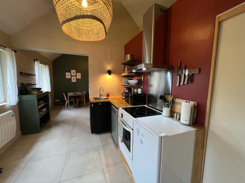 Il comprend une cuisine équipée d'une cuisinière et d'un four blanc. dans l'établissement Le Nid~Aux portes de Chambord~, à Maslives