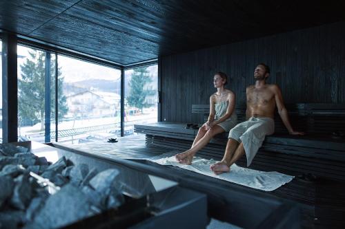 a man and a woman sitting on a bench at Hotel Nordik Adults Only - Over 14 in Andalo