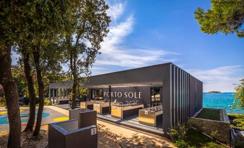 a store with a row of tables in front of the water at Maistra Camping Porto Sole Pitches in Vrsar