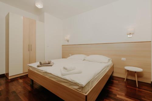 a bedroom with a large bed with white sheets and a table at Bed and Breakfast Kolo Adults only in Novigrad Istria