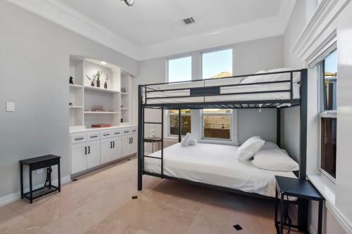 um quarto com um beliche num quarto branco em Cozy and Roomy Home with Private Pool em Houston
