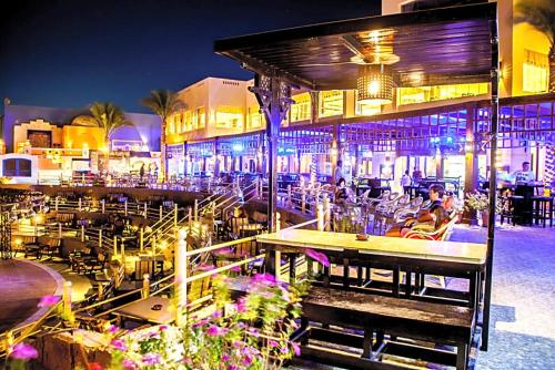een restaurant met tafels en stoelen 's avonds bij Apartment at ElKarma Aqua beach Resort in Hurghada