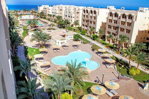 een luchtzicht op een resort met een zwembad en parasols bij Apartment at ElKarma Aqua beach Resort in Hurghada