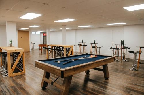 a pool table in a room with tables and chairs at Suite 208 - Destination Mont-Orford in Magog-Orford