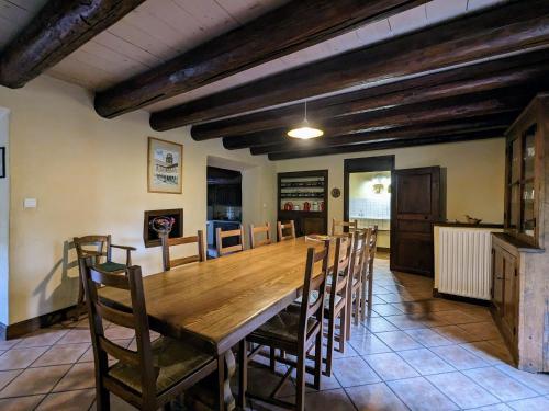 une grande salle à manger avec une table et des chaises en bois dans l'établissement Gîte familial avec grande terrasse à Auzat, proche baignades et sites historiques - FR-1-582-183, à Villeneuve-dʼAllier
