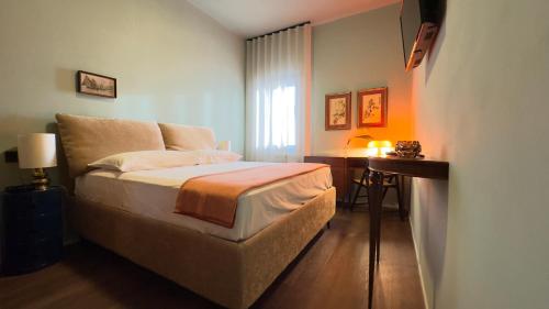 a small bedroom with a bed and a desk at Novo Taccheo by Ca-Sa Check in Chioggia