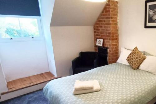 1 dormitorio con 1 cama, 1 silla y 1 ventana en CNTRL Reading Modernized 3 bedroom House en Reading