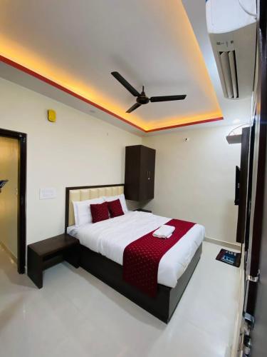 a bedroom with a bed with a ceiling fan at Hotel Pru with car parking in Alambagh