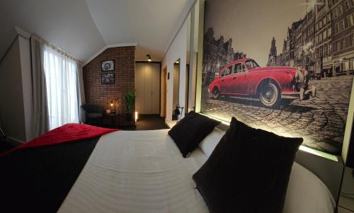 a bedroom with a bed with a red car on the wall at Hotel Spa El Muelle de Suances in Suances