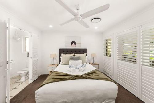 a white bedroom with a large bed and a toilet at Large Noosaville Gem - Off Gympie Terrace in Noosaville