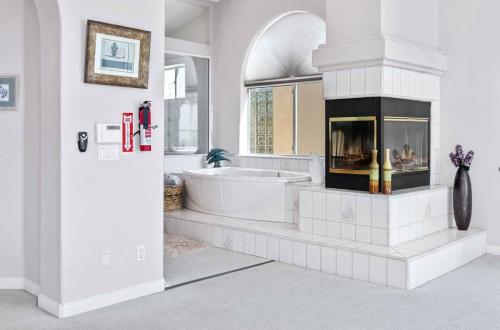 uma casa de banho branca com uma banheira e uma lareira em Panoramic View Villa with Pool - Events OK em Ramona