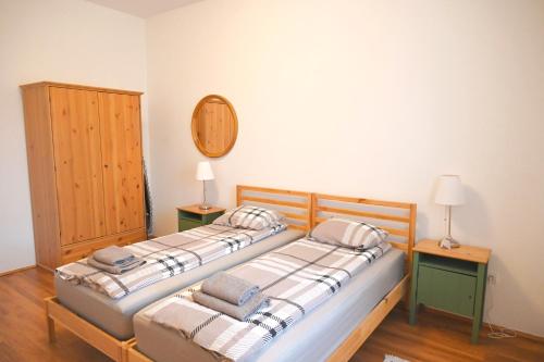 2 camas en una habitación con 2 lámparas y un espejo en Erdődy Vendégház, en Kastélyosdombó