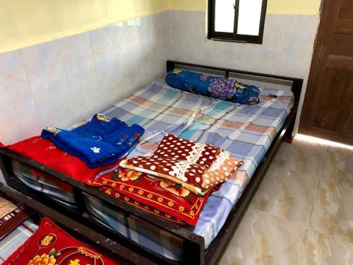 a bed with two pillows on top of it at Countryside Schoolstay in Takeo