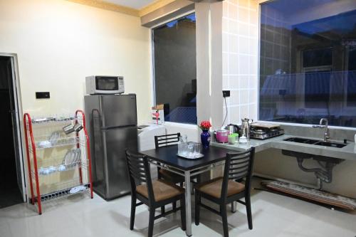 a small kitchen with a table and a refrigerator at Eye Catch Kandy in Kandy