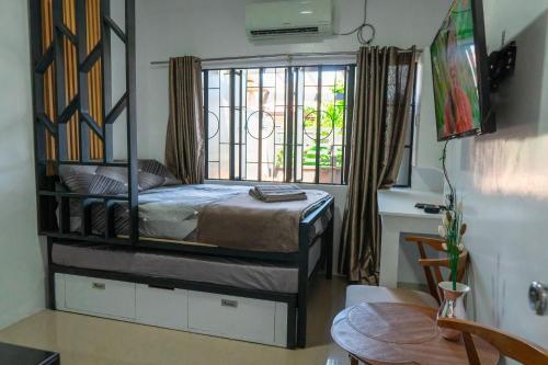 een slaapkamer met een hemelbed en een raam bij Apartment near Malls in General Santos