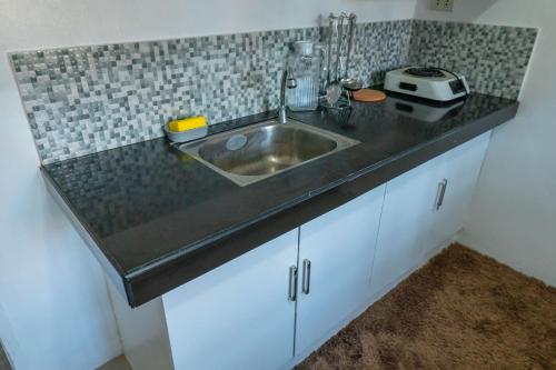 a kitchen counter with a sink and a toaster on it at Apartment near Malls in General Santos