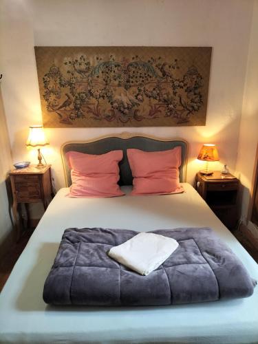 une chambre avec un grand lit avec des oreillers roses dans l'établissement MAISON ST CHRISTOPHE, à Lézardrieux