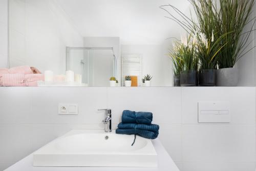 a white bathroom with a sink and a mirror at Apartament Gocławska SWPS PGE Narodowy Dworzec Wschodni Soho Factory in Warsaw