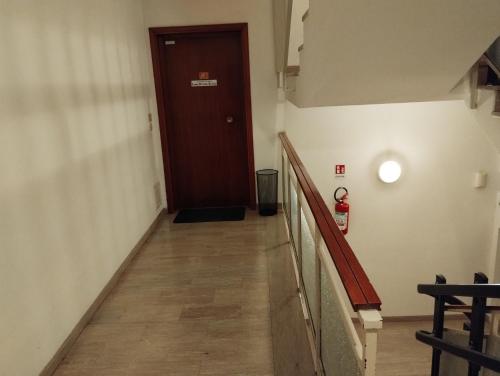 a hallway with a brown door and a wooden floor at EasyRoom Schio in Schio