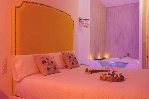 um quarto com uma cama com uma cabeceira amarela e uma banheira em LOFT TÚ y YO em Alcalá del Júcar