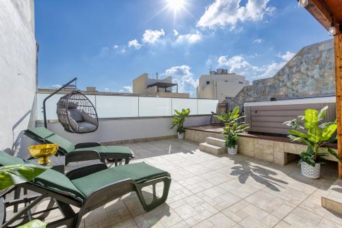 a rooftop patio with chairs and a swing at Sliema Luxury House in Sliema