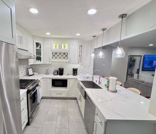 a kitchen with white cabinets and white appliances at Rainforest Villa 4 Bedroom PoolSpa Walk2Disneyland in Anaheim