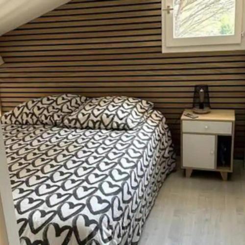 une chambre avec un lit avec une couette noire et blanche dans l'établissement Maison Plein Sud - 4 voyageurs par Conciergerie Key With Us, à La Motte