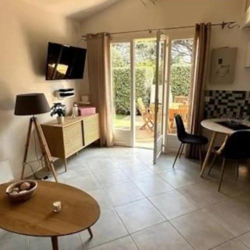 un salon avec une table, des chaises et une télévision dans l'établissement Maison Plein Sud - 4 voyageurs par Conciergerie Key With Us, à La Motte