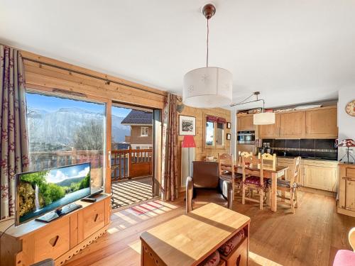 une cuisine et un salon avec une grande fenêtre dans l'établissement 4 pieces centre village, aux Carroz d'Arâches