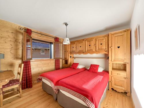 une chambre avec un lit avec une couverture rouge dans l'établissement 4 pieces centre village, aux Carroz d'Arâches