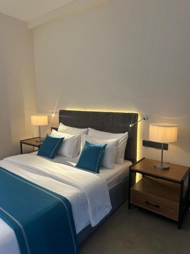 a bedroom with a large bed with blue and white pillows at Amore Resorts in Kobbekaduwa