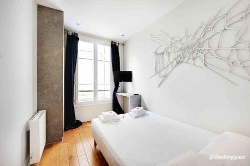 Cette chambre blanche dispose de deux lits et d'une fenêtre. dans l'établissement Center Paris Louvre - Tuilerie, à Paris