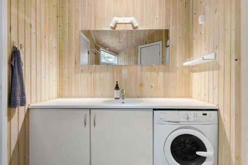 ein Badezimmer mit einer Waschmaschine und einem Waschbecken in der Unterkunft Little Fiskerbanke - Lovely, Private, And Family-friendly Holiday Home in Saltum