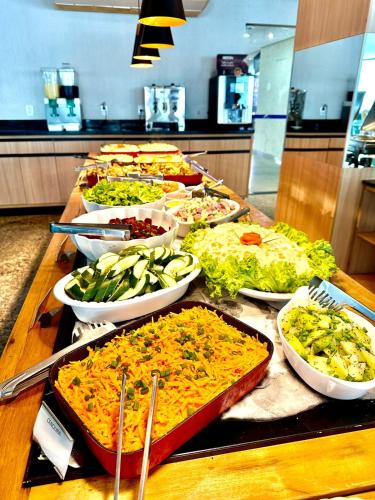 a buffet with many different dishes of food on a table at Prime Hotel Águas da Serra in Rio Quente