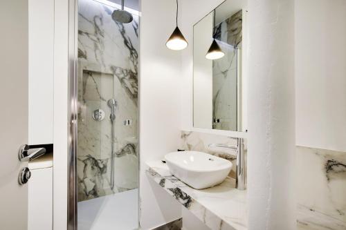 um banheiro branco com pia e chuveiro em Pick A Flat's Apartment in Saint-Michel - Rue Pestalozzi em Paris