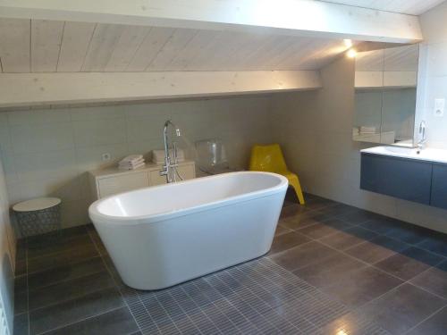 a white bath tub in a bathroom with a sink at Grande maison rénovée, piscine, 4 chambres, vaste terrain, près piste cyclable et pêche, Wi-Fi inclus - FR-1-426-408 in Fontenay-le-Comte