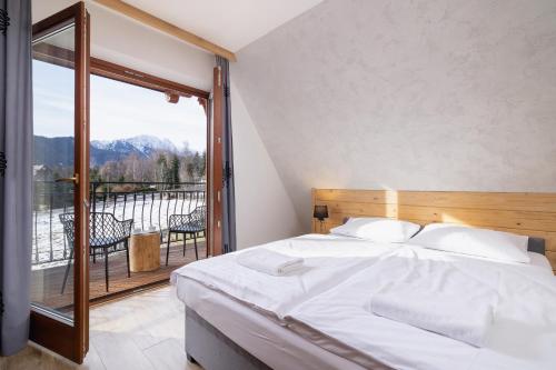 a bedroom with a bed and a large window at Tatry Design Suite Mountain View Apartment & Parking by Renters in Zakopane