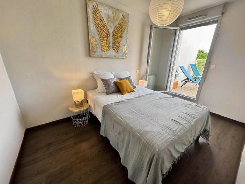 a bedroom with a bed and a sliding glass door at Villa lumineuse T3 - Proche Aéroport MEETT Airbus in Aussonne