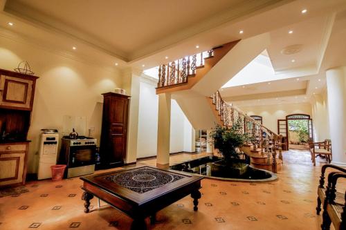 un grand salon avec un escalier et une table dans l'établissement The Kabok Villa by Vivanya, à Ambalangoda