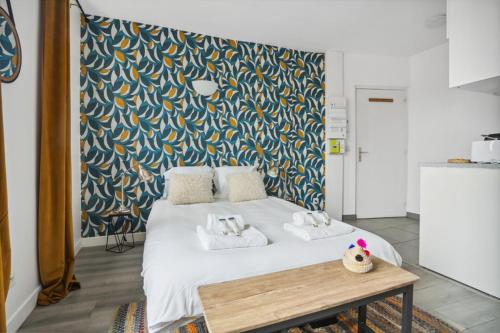 um quarto com uma grande cama branca e uma mesa em 811 Suite Dream - Superb apartment em Bagnolet