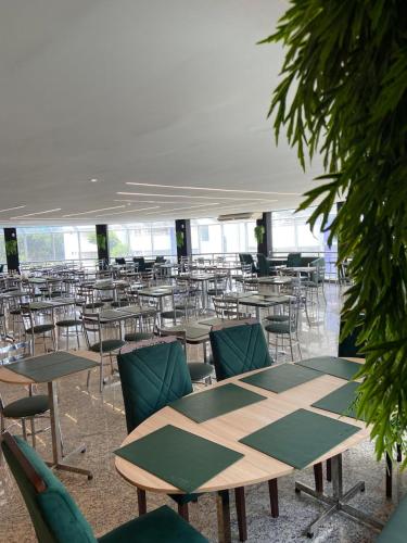an empty room with tables and chairs in a building at Prime Hotel Águas da Serra in Rio Quente